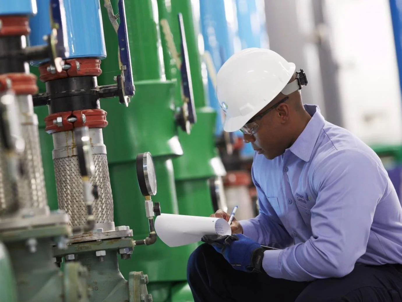 HVAC mechanic recording equipment readings during an inspection
